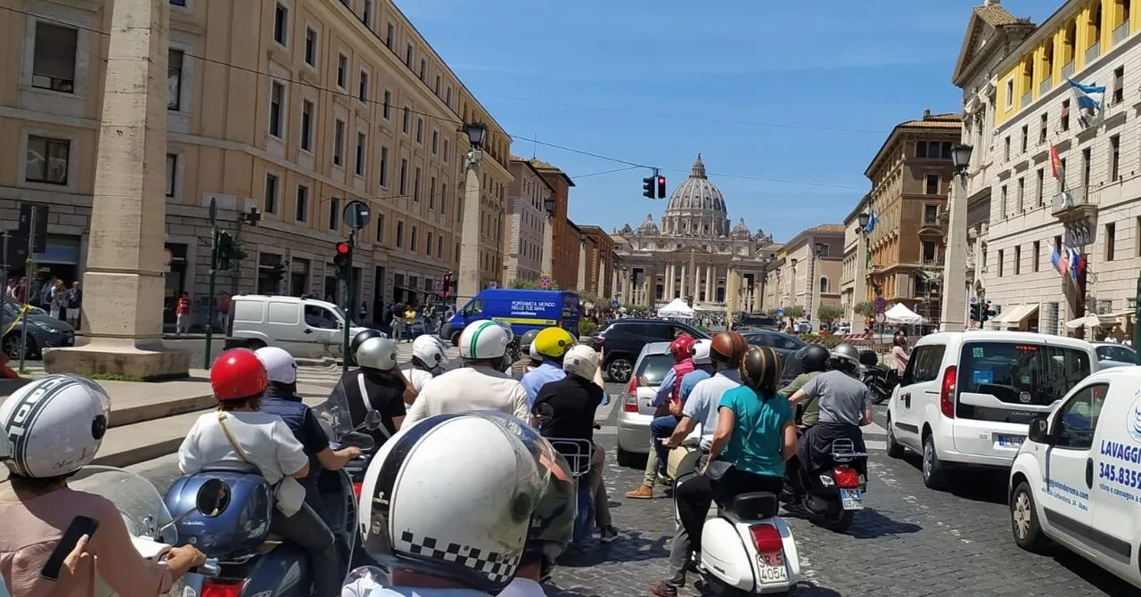 Group on Vespas in city centre traffic with St Peter's dome in the background