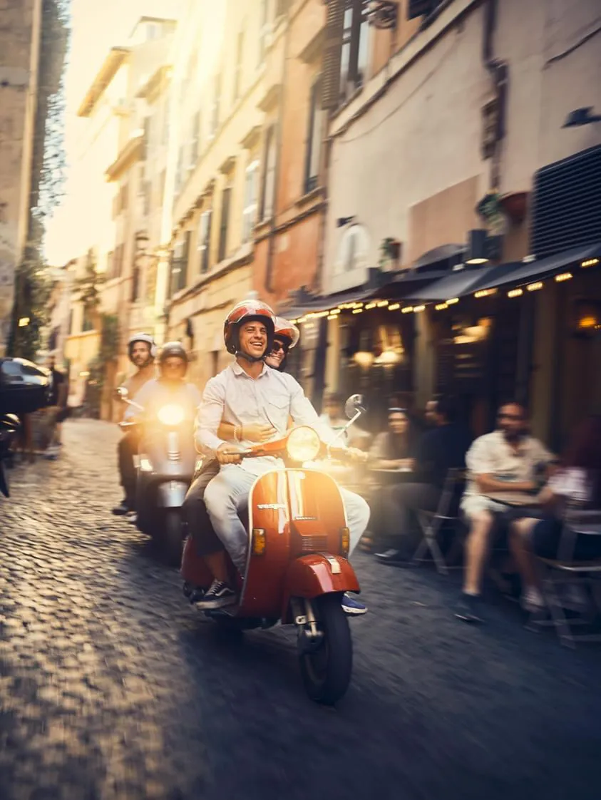 Group on Vespas through the alleys of the historic centre at sunset