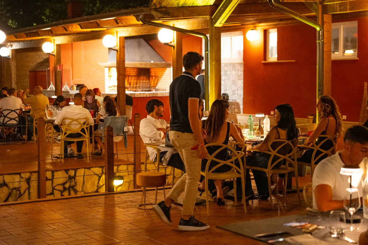 Guests dining in the illuminated garden at Tiber Village