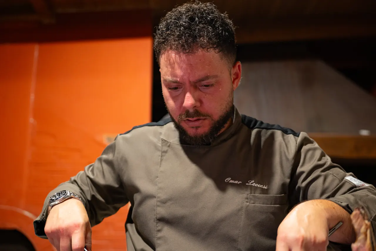 The chef carving fire-grilled meat