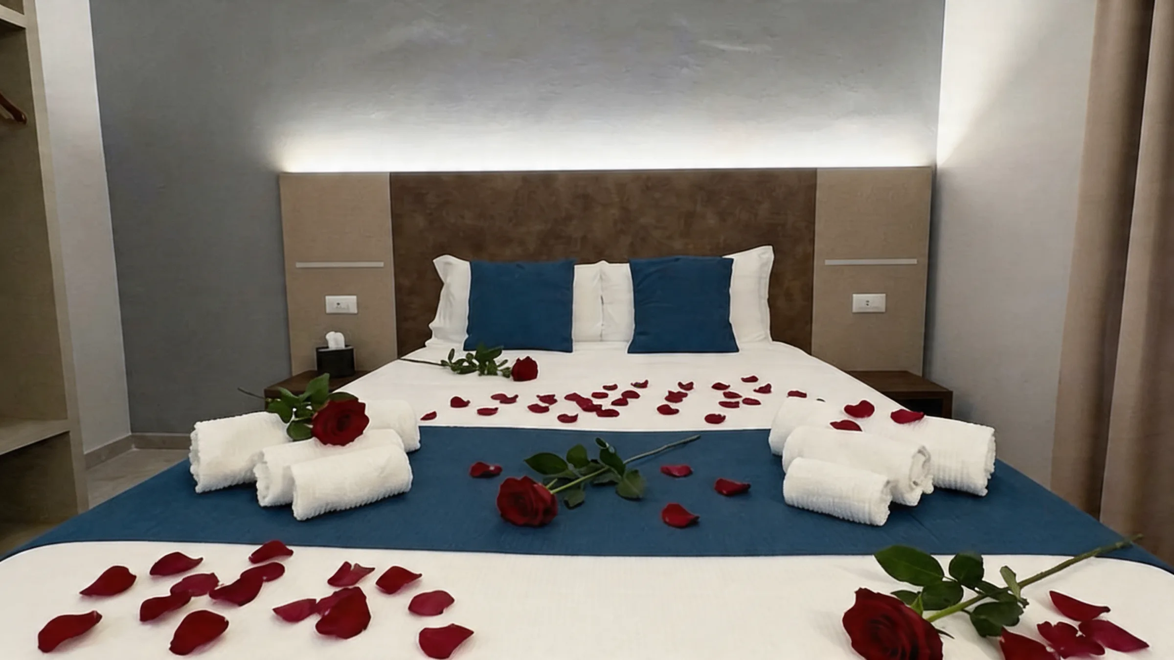 Camera romantica del Tiber Village con petali di rose rosse e asciugamani, letto matrimoniale elegante